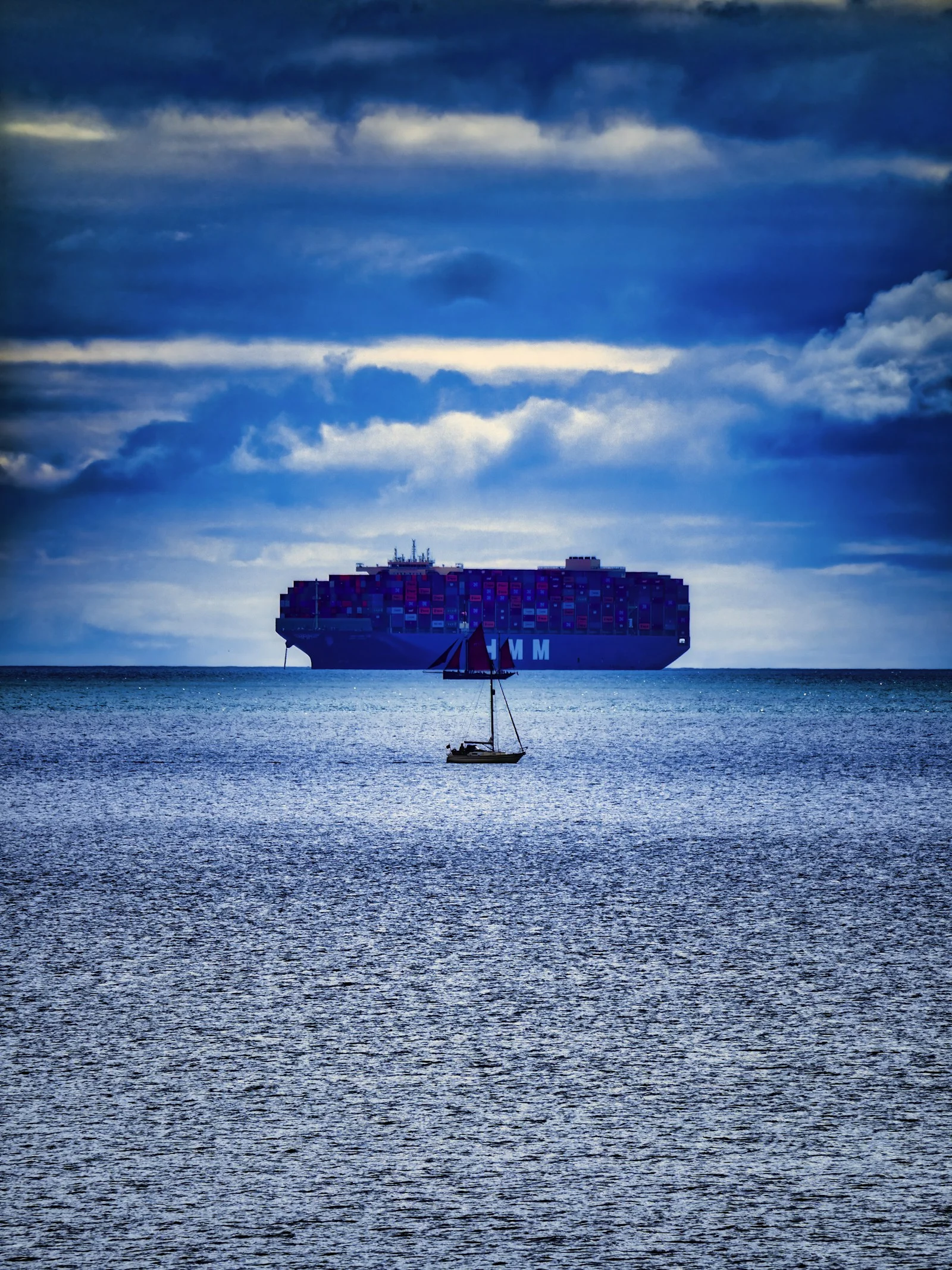 Cargo ship crossing open blue ocean
